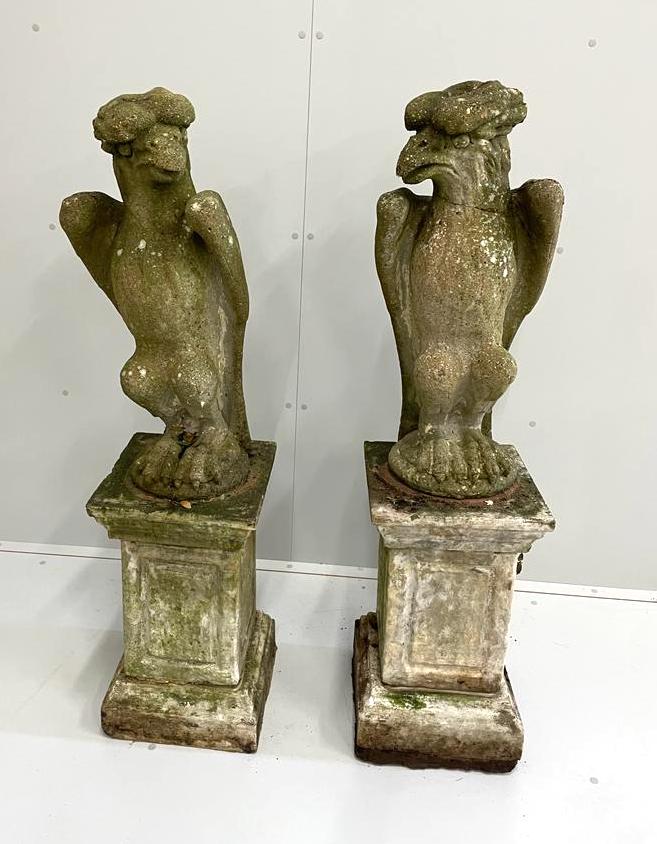 A pair of reconstituted stone models of eagles, on square plinths, height 125cm (eagle head cracked)